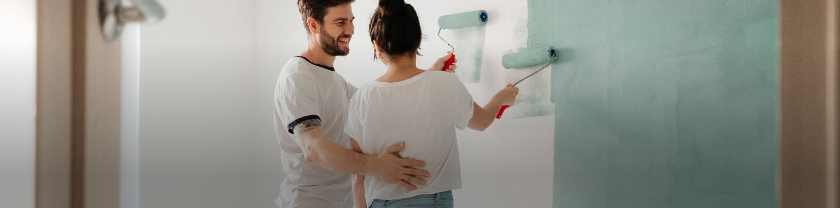 man and woman painting wall